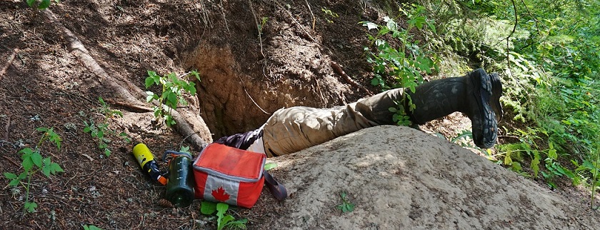 RN Simon inspectant une tanière de loup